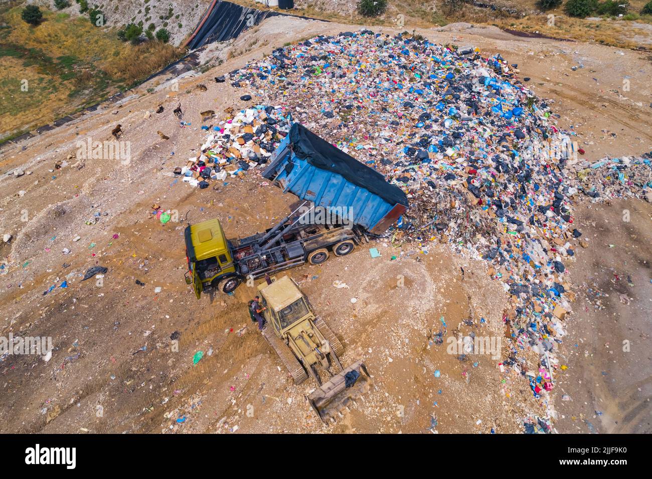 Beach landfill. Trucks working on sandy ground and throwing plastic trash straight to the sand. Recycling and climate change concept. High quality photo Stock Photo
