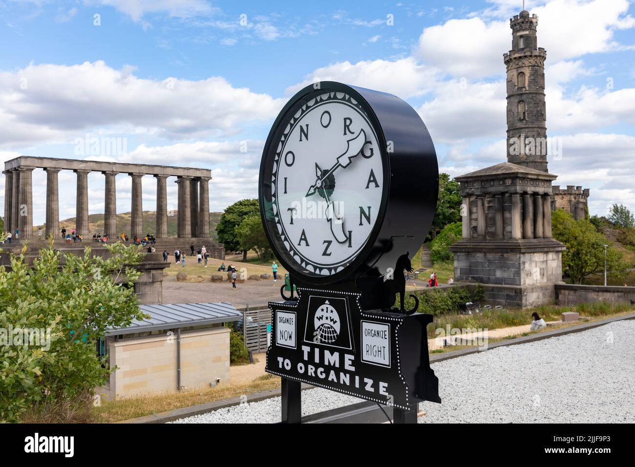 Calton Hill Edinburgh, Silent Agitator time to organise on display, Nelson Monument and the National Monument of Scotland behind,UK,Europe Stock Photo