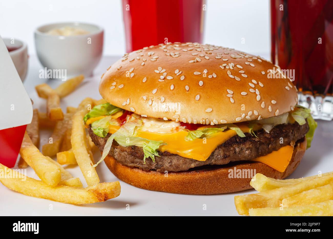 soft sesame seed bun, juicy fresh lettuce, melted cheese and BBQ flavored beef patty. Hot, crispy and delicious french fries with sparkling cola. Fast Stock Photo