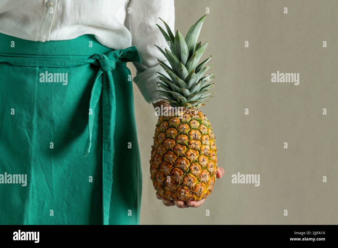 Woman holding pineapple, close up of fruit - stock photo Stock Photo