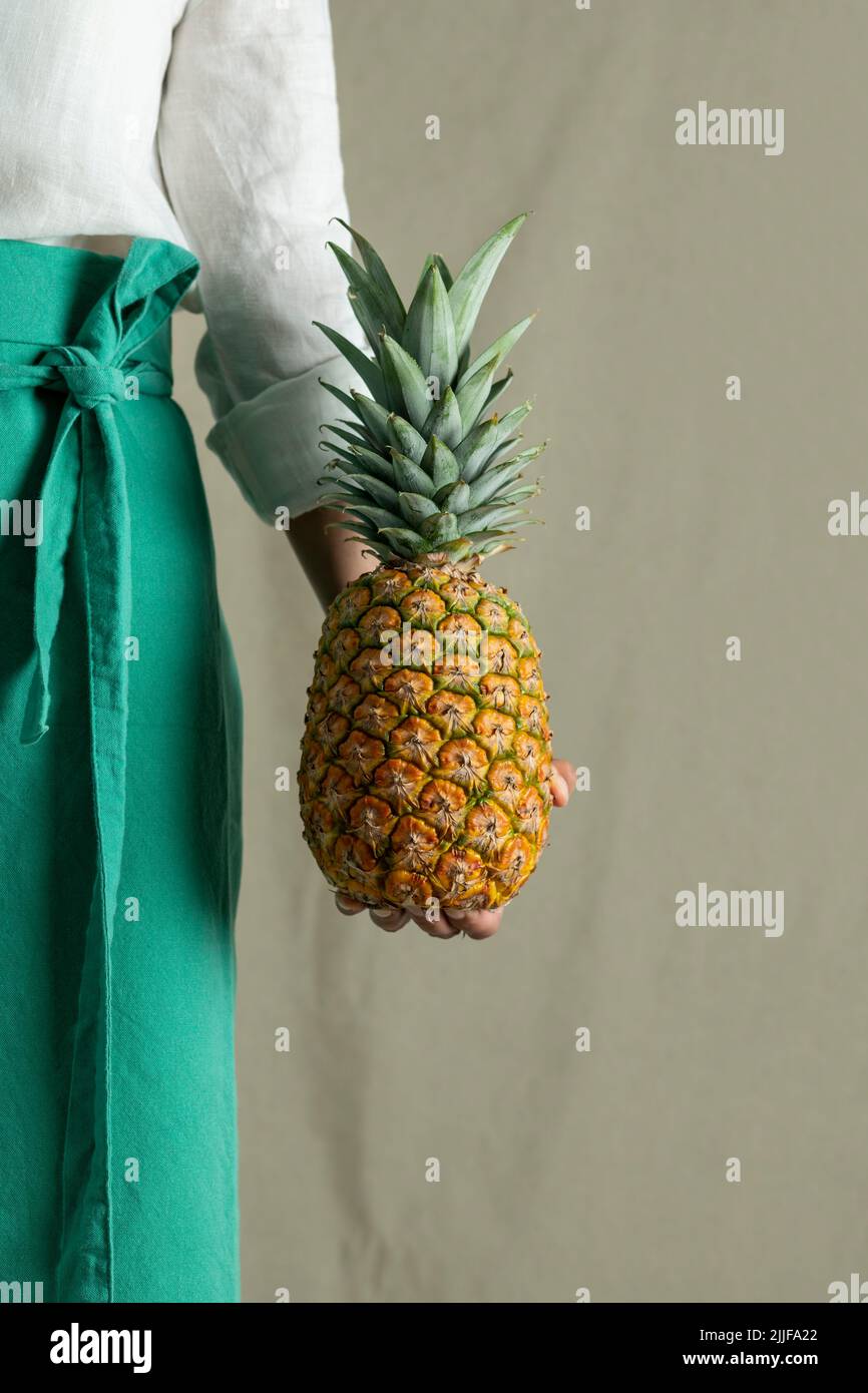 Woman holding a pineapple, close up of fruit - stock photo Stock Photo