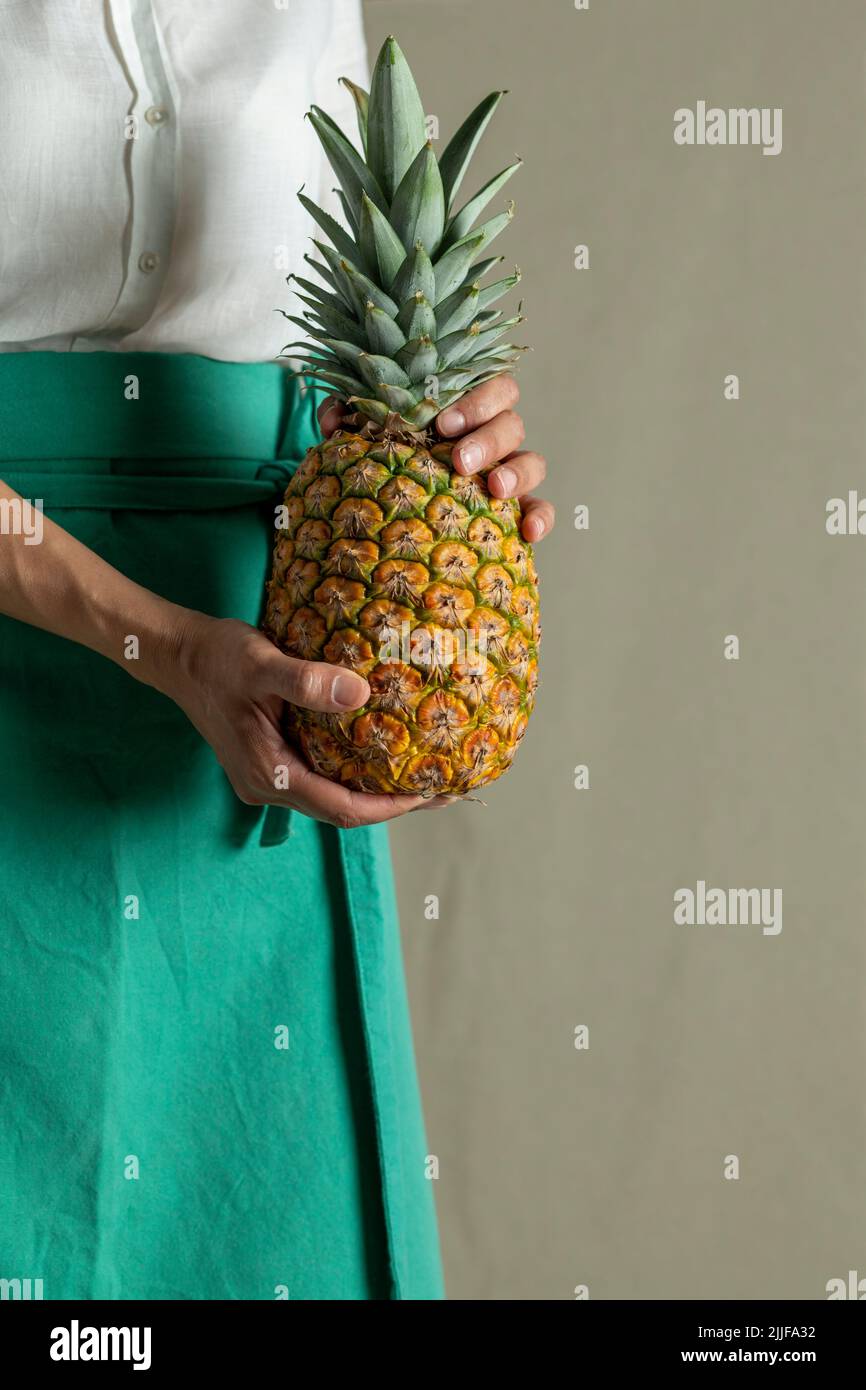 Woman holding a pineapple, close up of fruit - stock photo Stock Photo