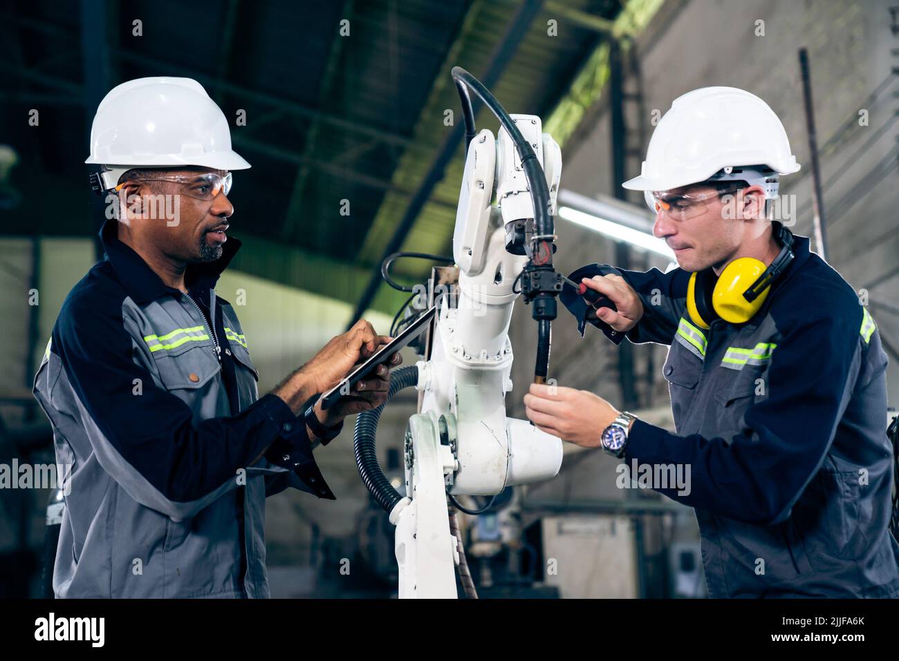 Factory workers working with adept robotic arm in a . Industry