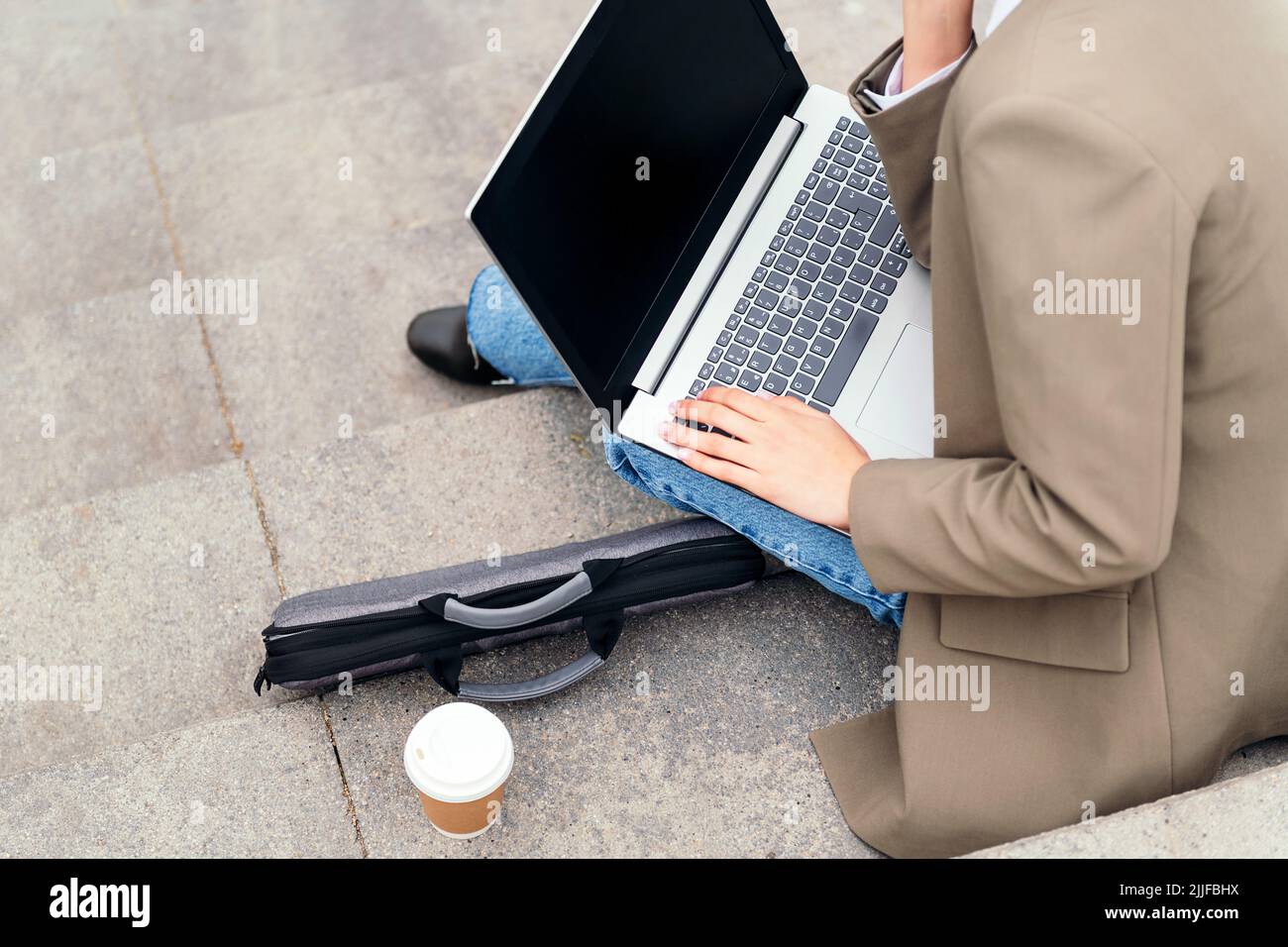 young woman working with laptop computer outdoors Stock Photo
