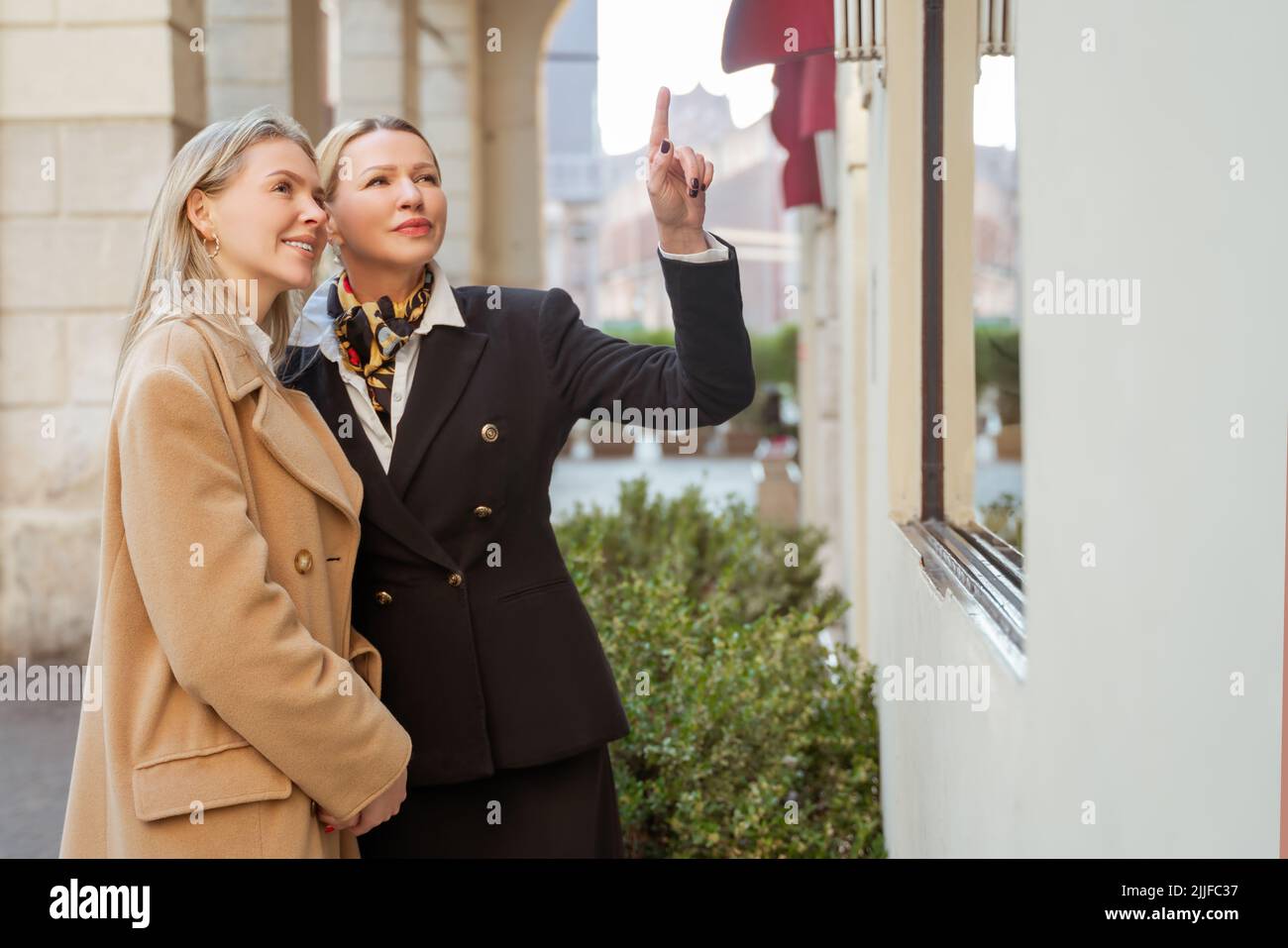 Lady showing places of interest to her female guest Stock Photo