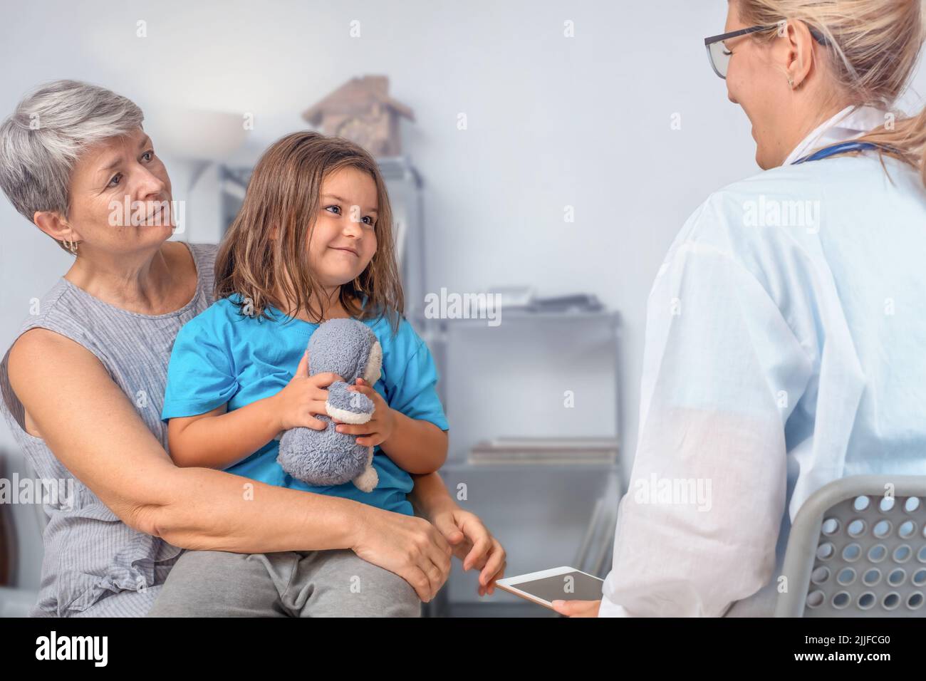 A child with a senior at a doctor's office appointment Stock Photo Alamy