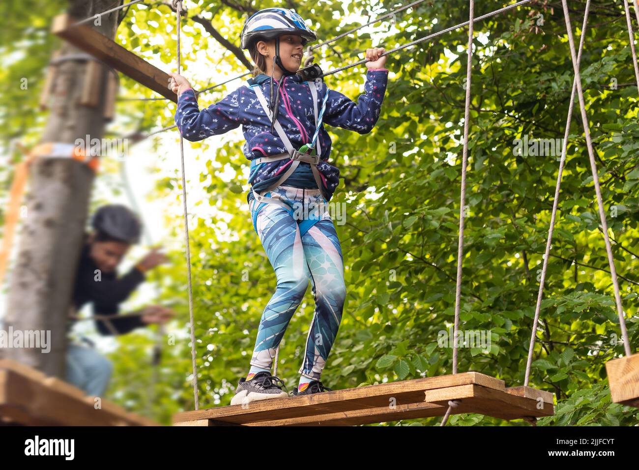 Little girl preschooler wearing full climbing harness having fun time