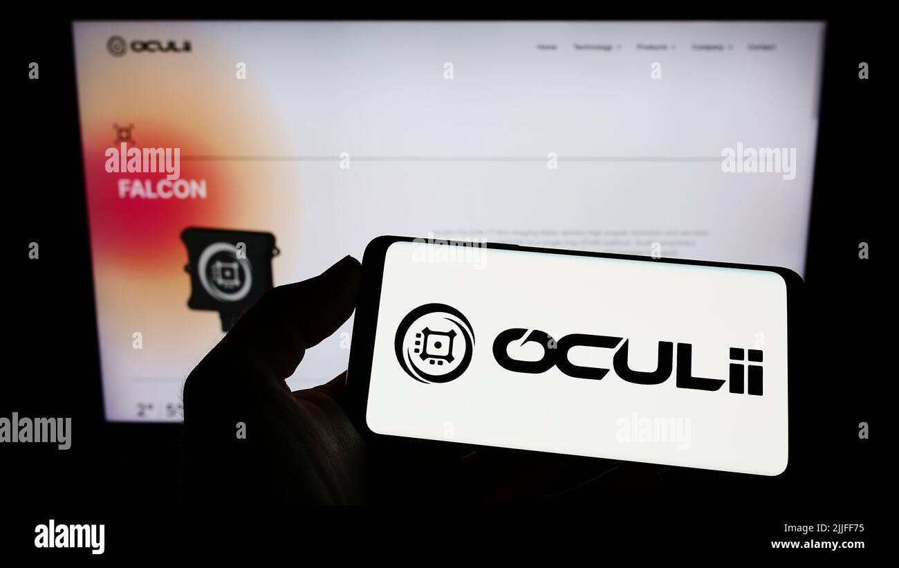Person holding mobile phone with logo of American radar technology company Oculii on screen in front of business web page. Focus on phone display. Stock Photo