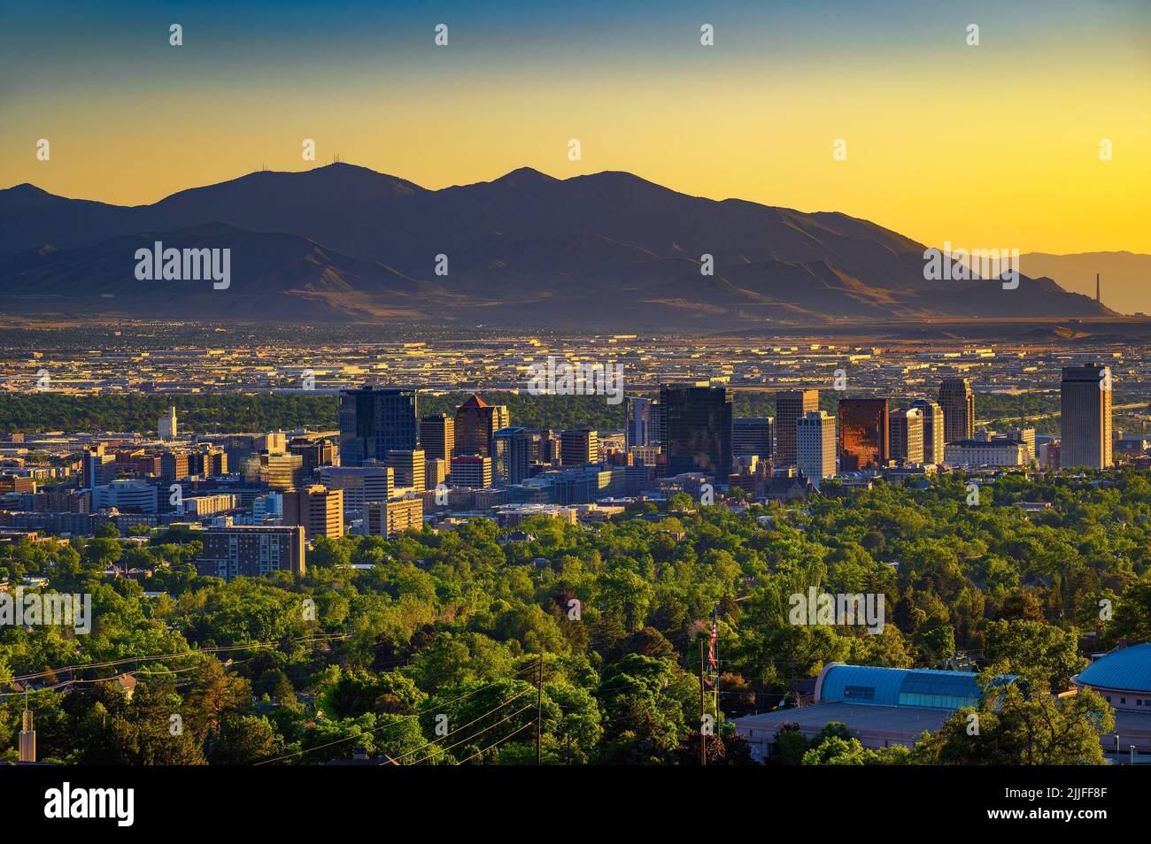 Salt Lake City skyline at sunset with Wasatch Mountains in the background, Utah Stock Photo