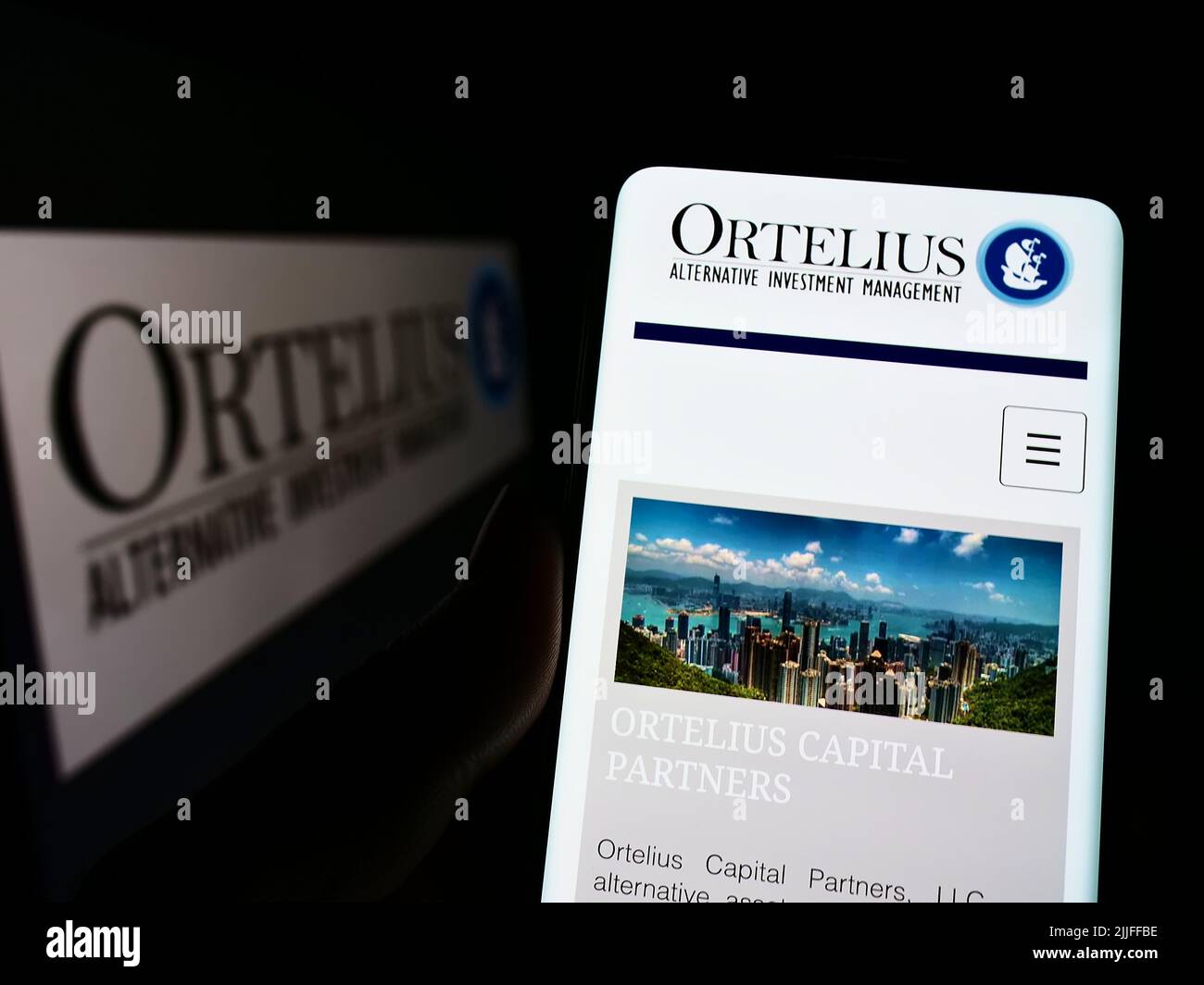Person holding mobile phone with webpage of US hedge fund company Ortelius Advisors LP on screen with logo. Focus on center of phone display. Stock Photo