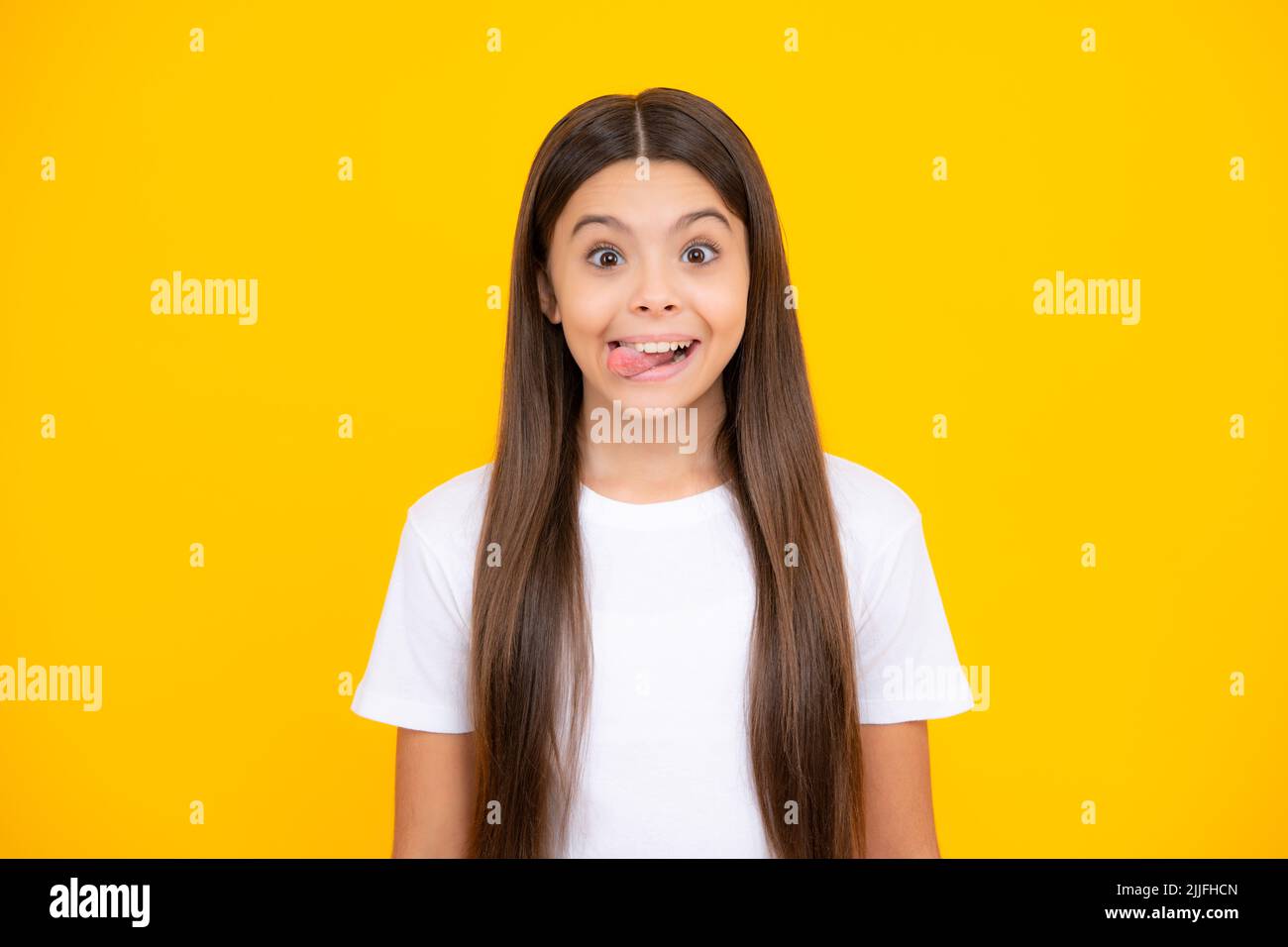 Funny kids face. Portrait of silly teenager child girl smiling and showing tongue in camera making funny faces. Stock Photo