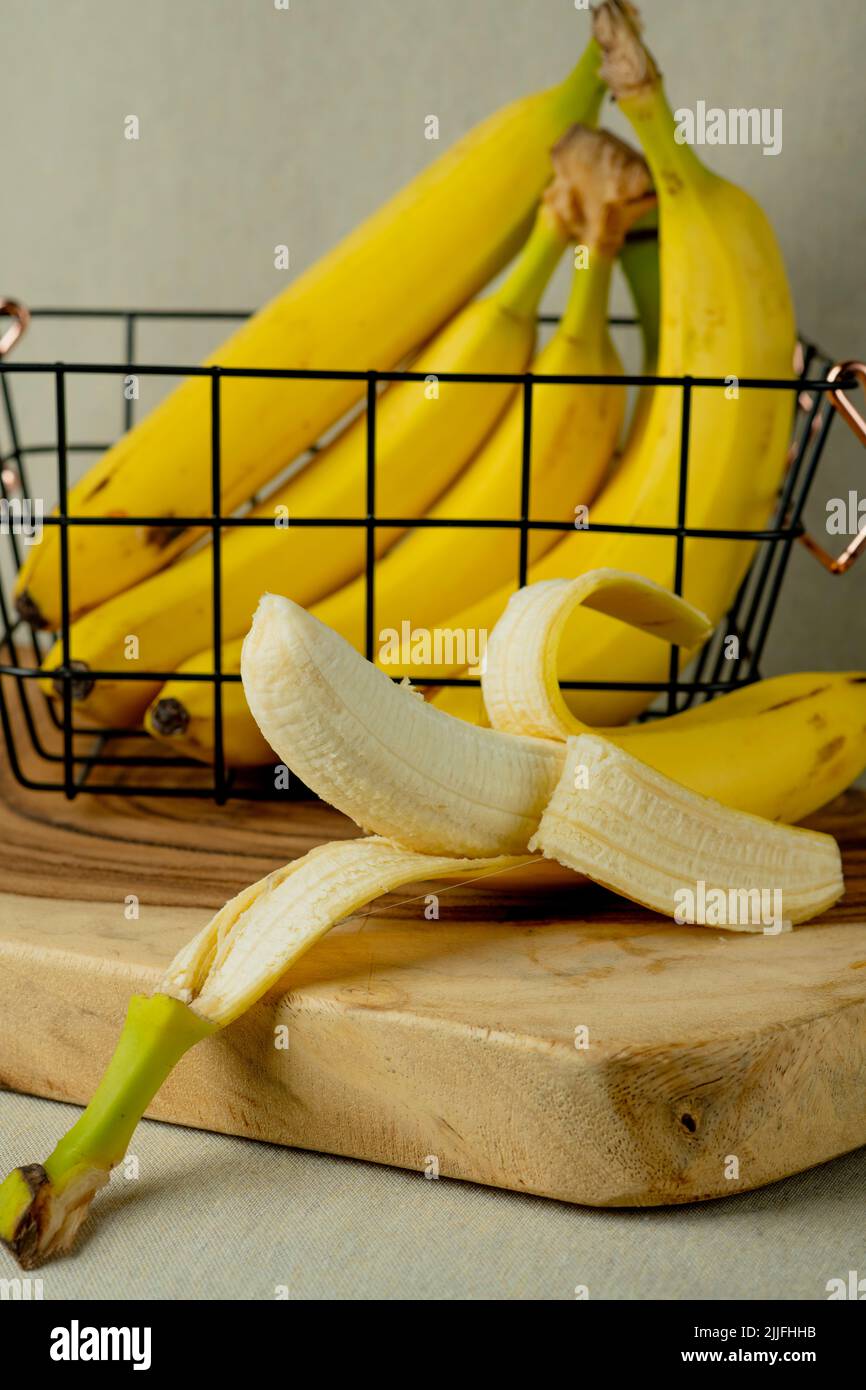 Fresh bananas and bananas cut into pieces in a bowl on the table - stock photo Stock Photo