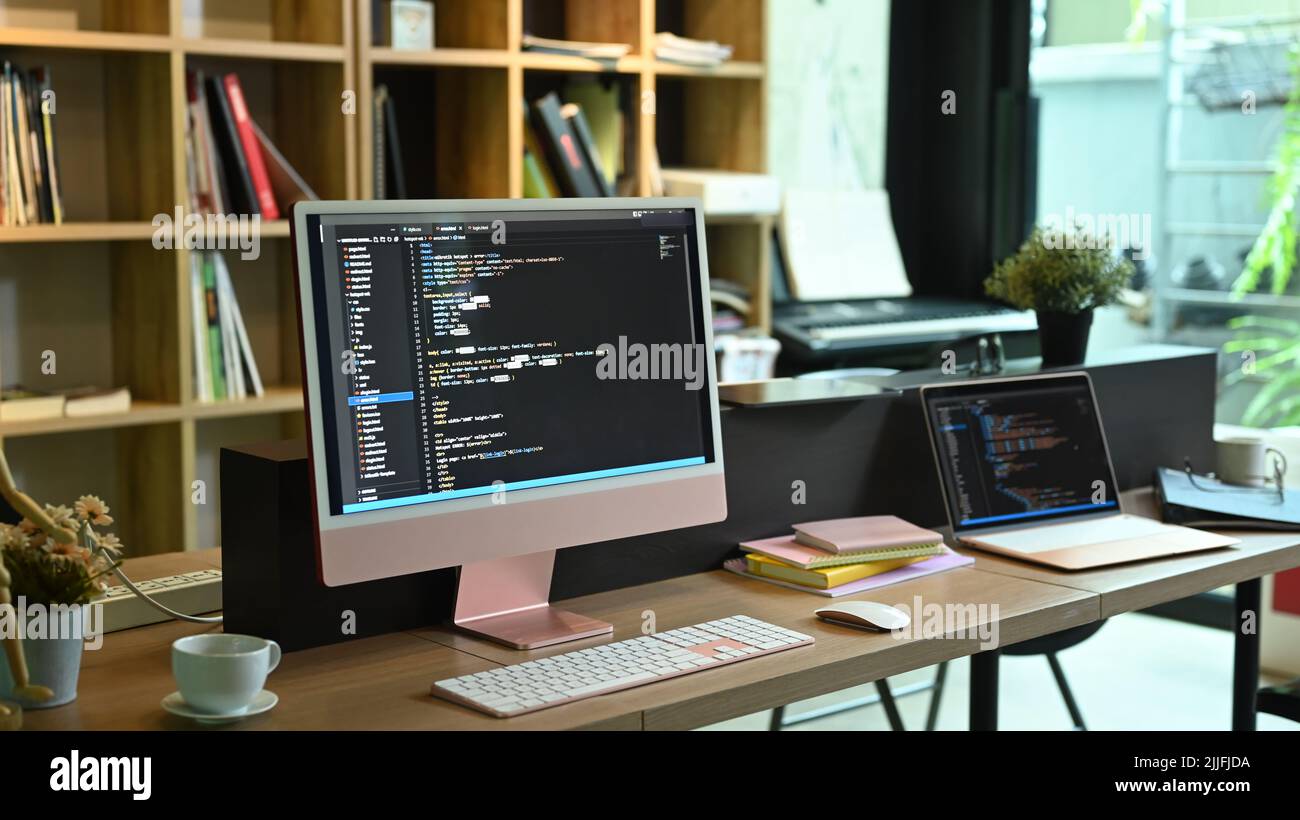 Computer pc and laptop with programming code on screens at software ...