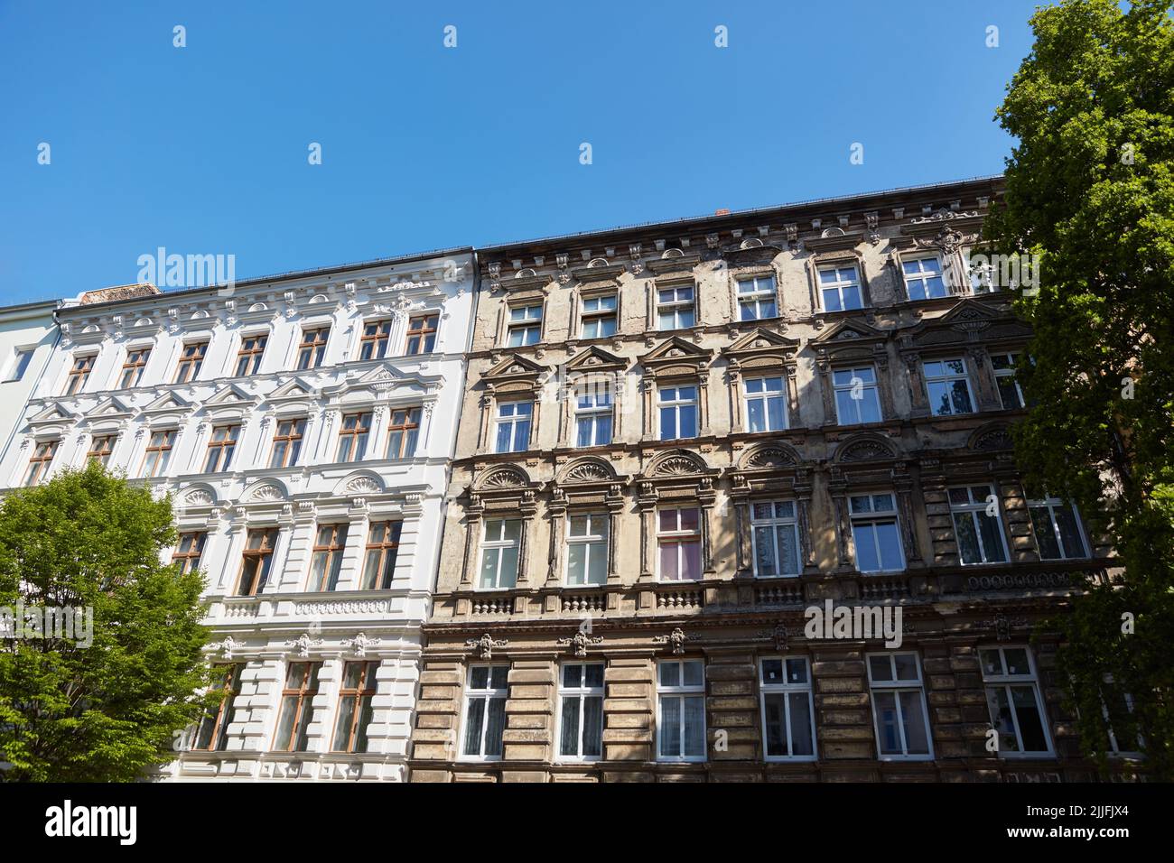 Comparison of old building facades before and after renovation and energetic insulation Stock Photo