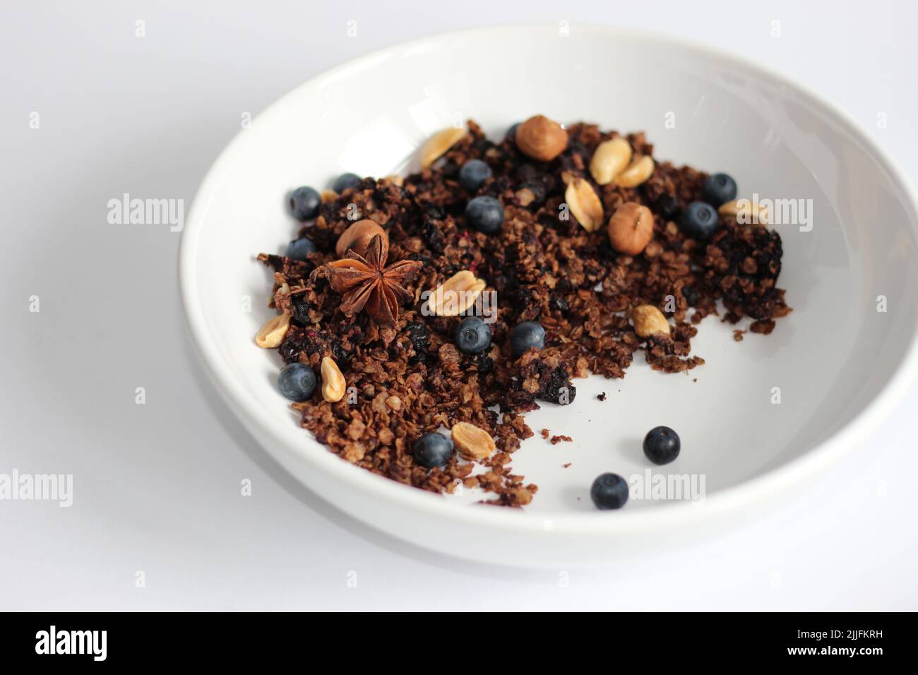 Homemade Granola with Nuts and Blueberries in White Bowl. Breakfast at Home. Stock Photo