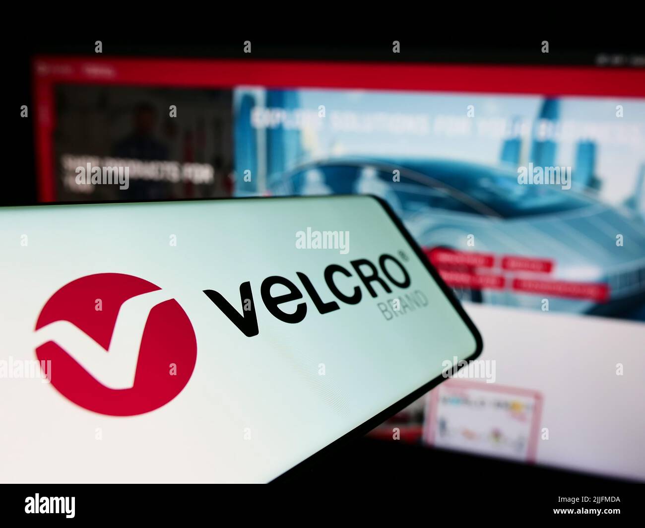 Cellphone with logo of British company Velcro IP Holdings LLC on screen in front of business website. Focus on center-left of phone display. Stock Photo