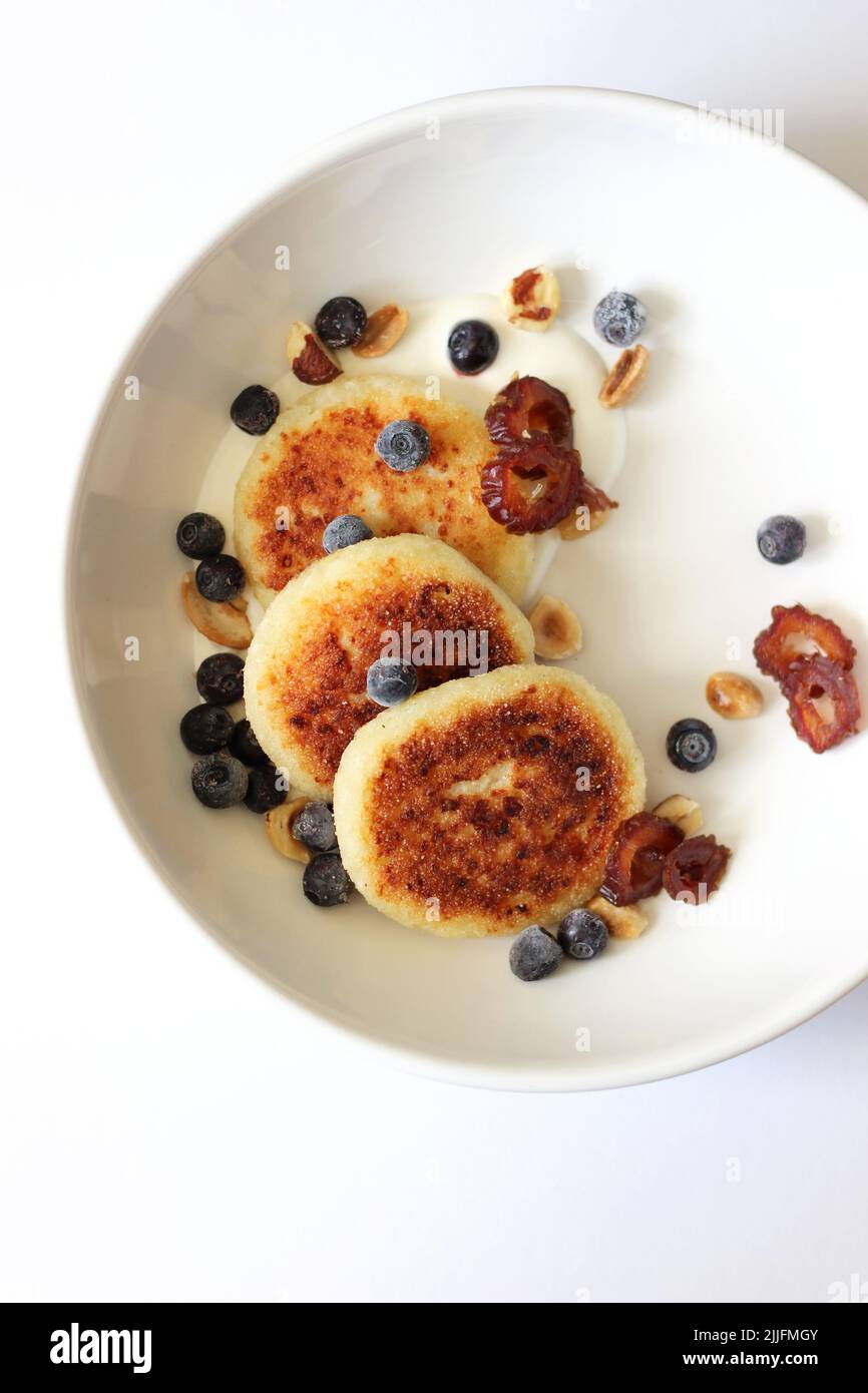 Breakfast Cottage Cheese Pancakes Served with Sour Cream, Blueberries, Nuts and Dates. Homemade Breakfast Concept. Stock Photo