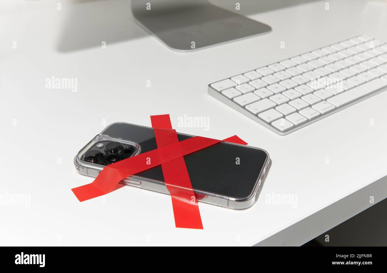 Mobile phone taped to desk Stock Photo