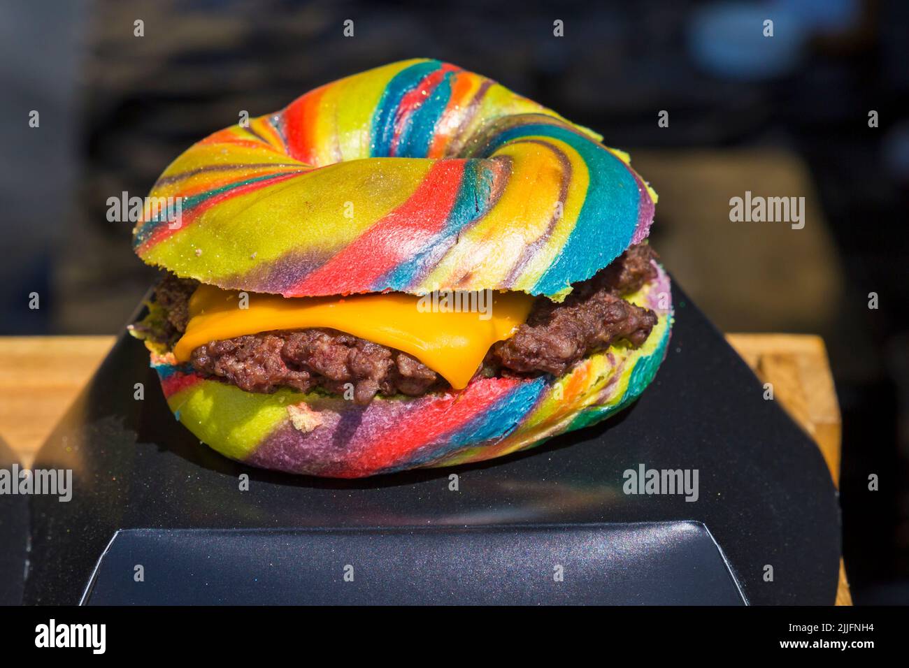 Unicorn Burger Hampshire minced steak rainbow bagel glitter for sale on food stall at event in Poole, Dorset UK in July Stock Photo