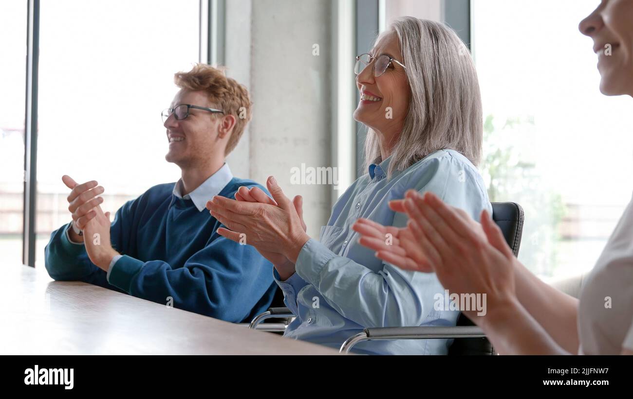 Business audience people group smiling applauding sitting at conference. Stock Photo