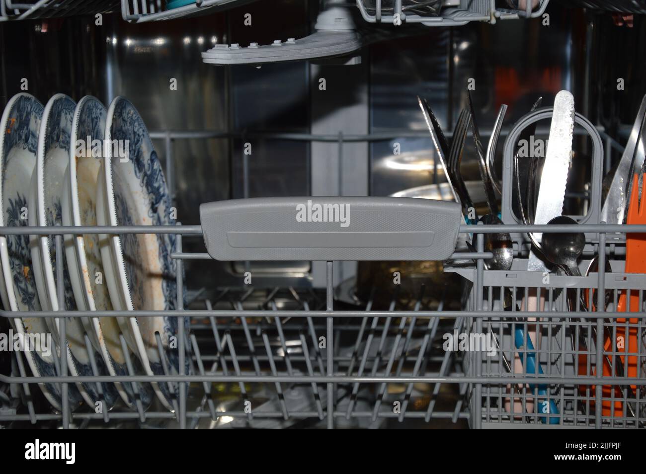 A closeup inside a dishwasher with dirty dishes, France Stock Photo