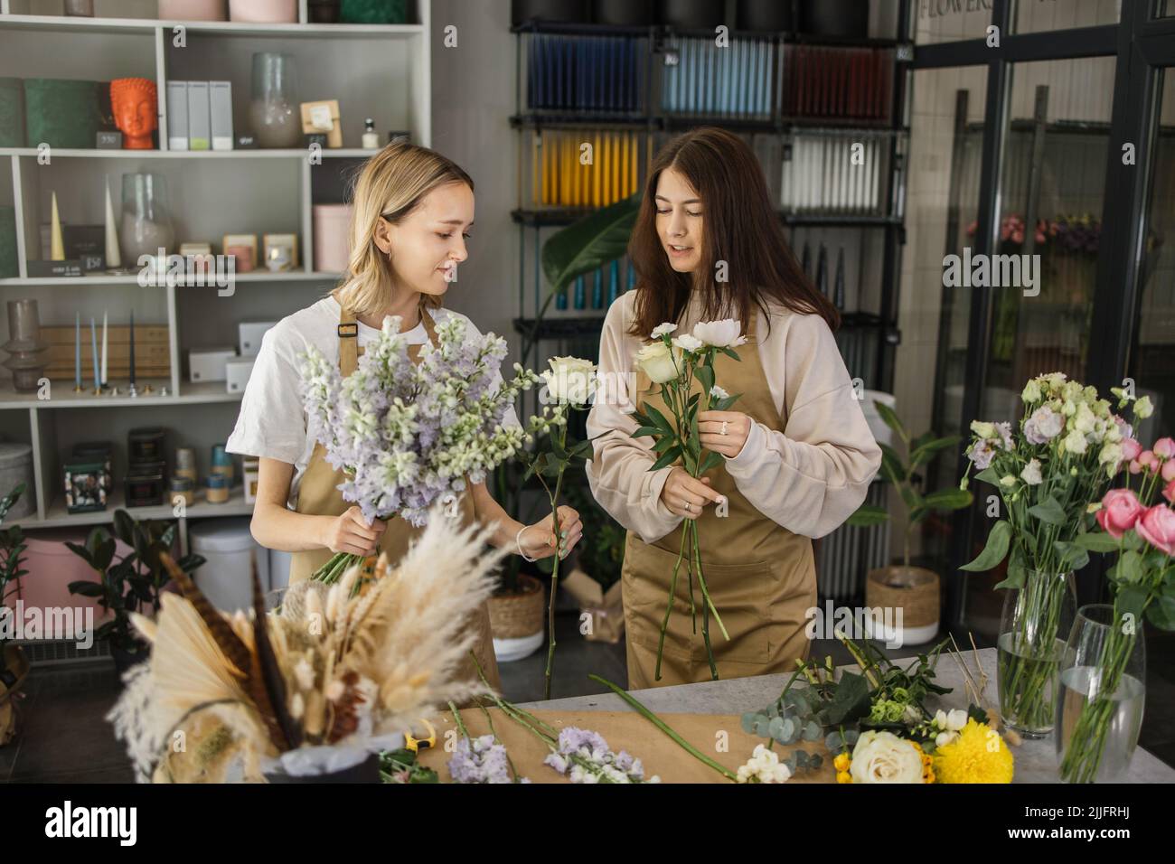 Portrait of overjoyed female florists enjoying occupation in retail