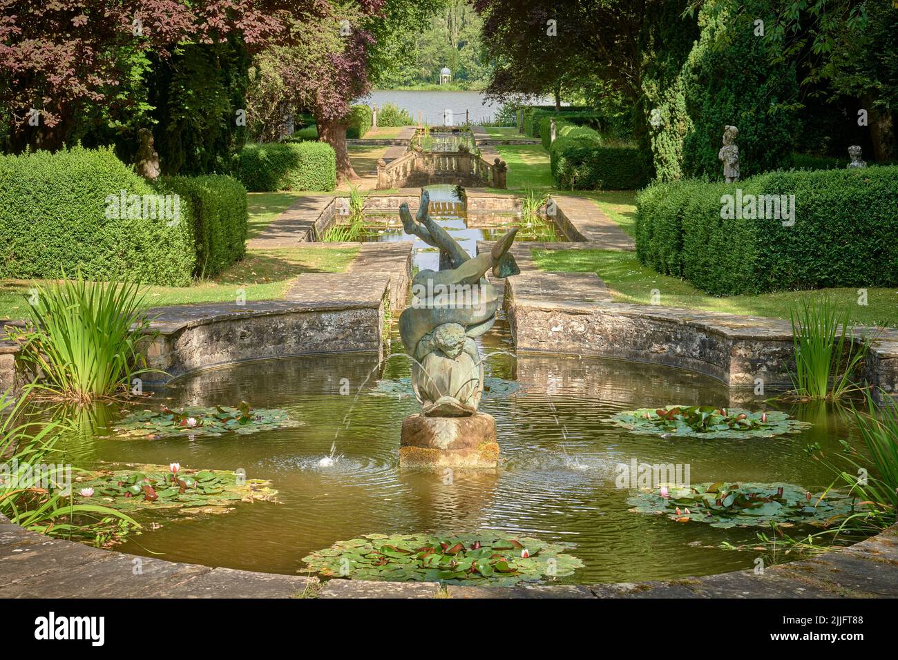 Formal lawned water gardens with water lillies and fountain Stock Photo