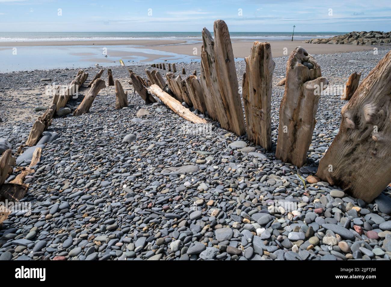 The wooden ribs of an old ship half-buried in the beach at Borth, Ceredigion, Wales Stock Photo