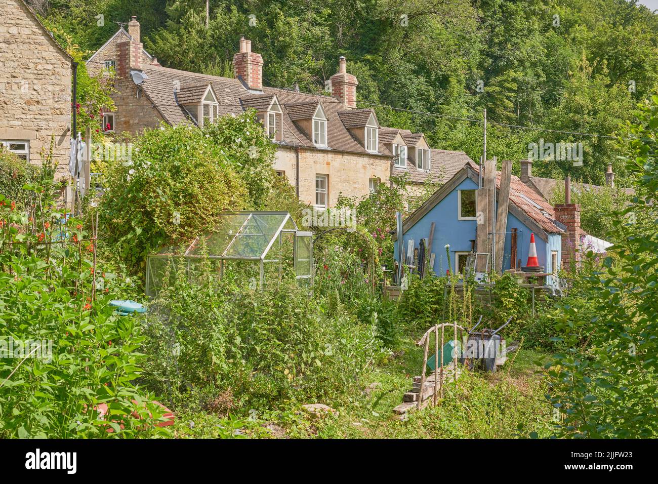 A row of Cotswold stone cottages with their back gardens Stock Photo