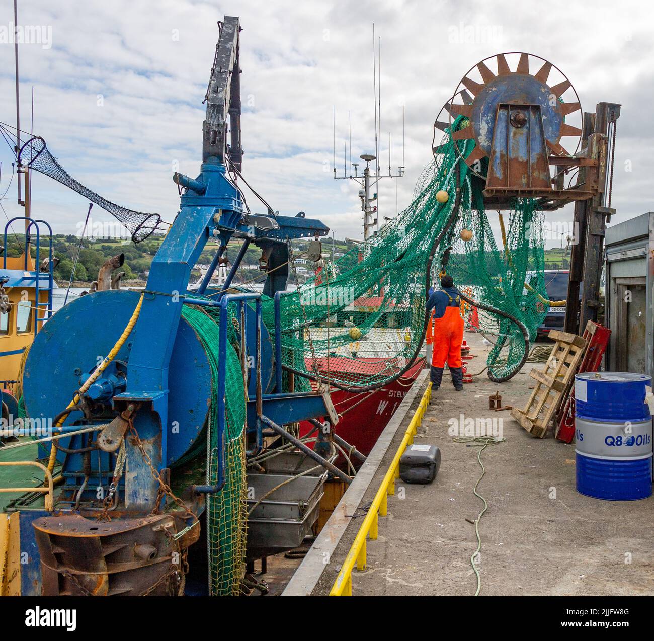 Fishing Trawler loading nets onboard from a reel on forklift truck Stock Photo