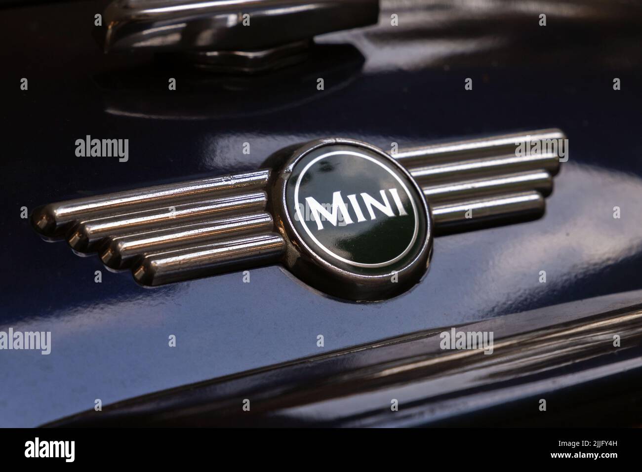 London, UK - November 30, 2021: Logotype of vintage Mini Cooper car produced by British Motor Corporation is on the shiny black car hood Stock Photo