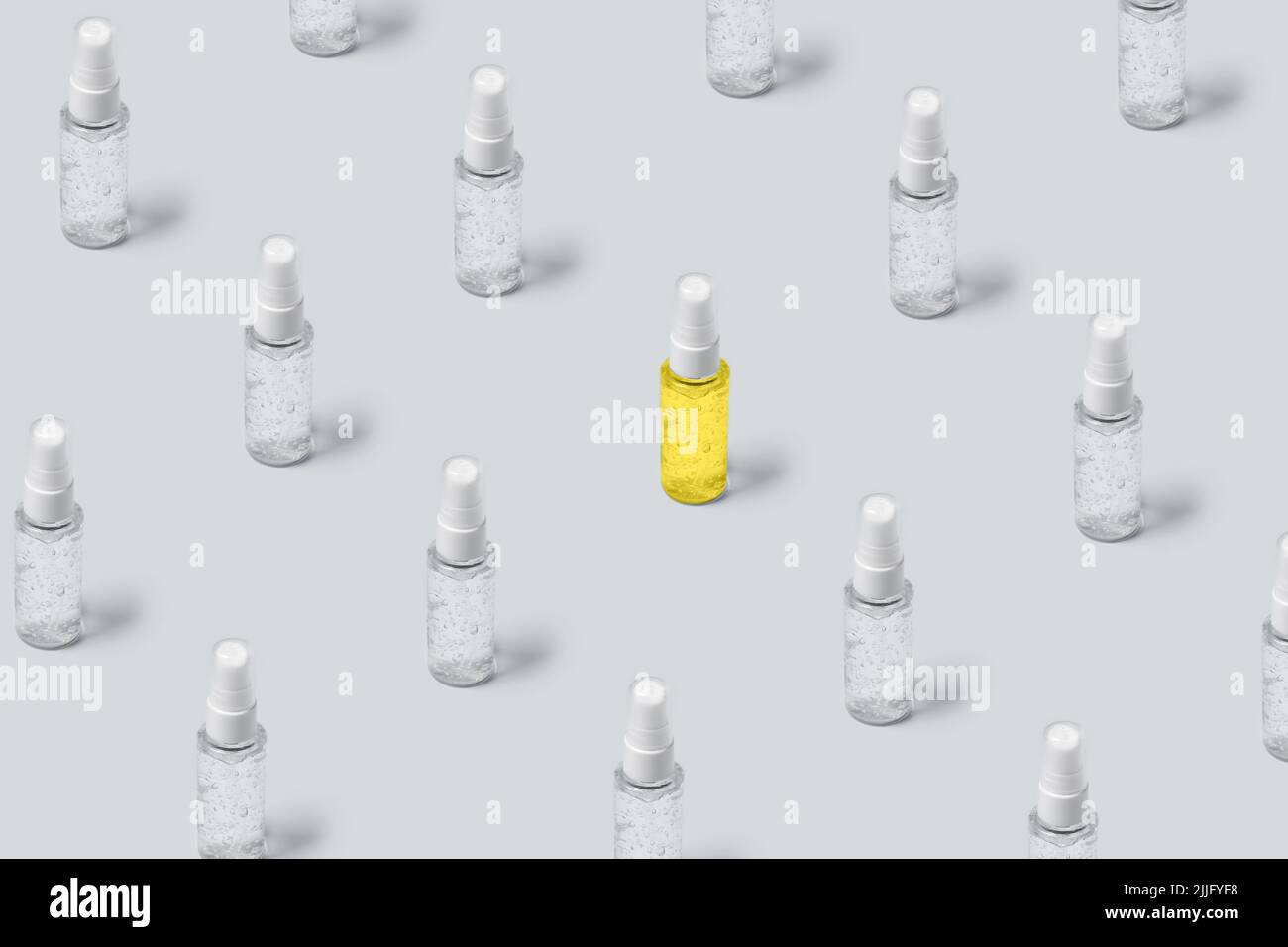 Pattern of bottles with gray and yellow filling on gray background. Advertising cosmetics in the trendy colors of the new year. Stock Photo