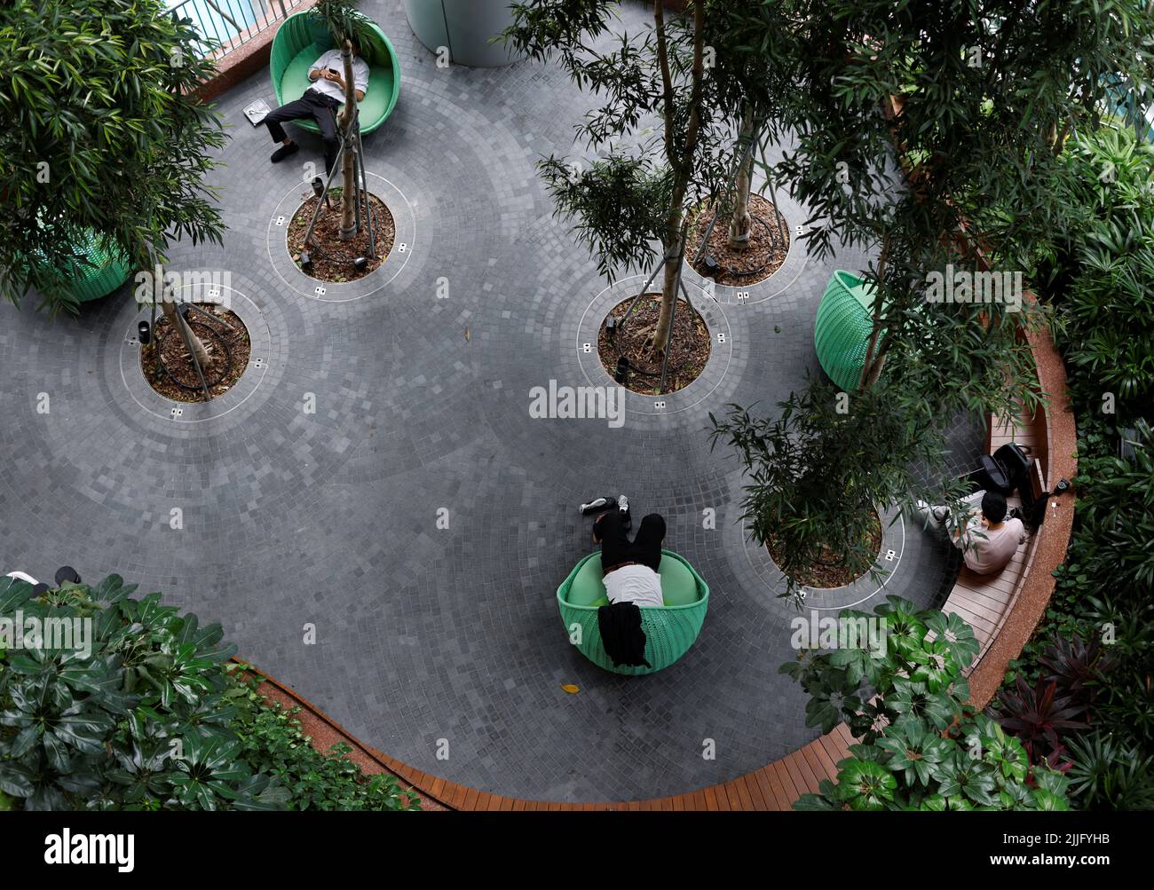Office workers take a nap at a rest area in the central business district in Singapore July 26, 2022. REUTERS/Edgar Su Stock Photo