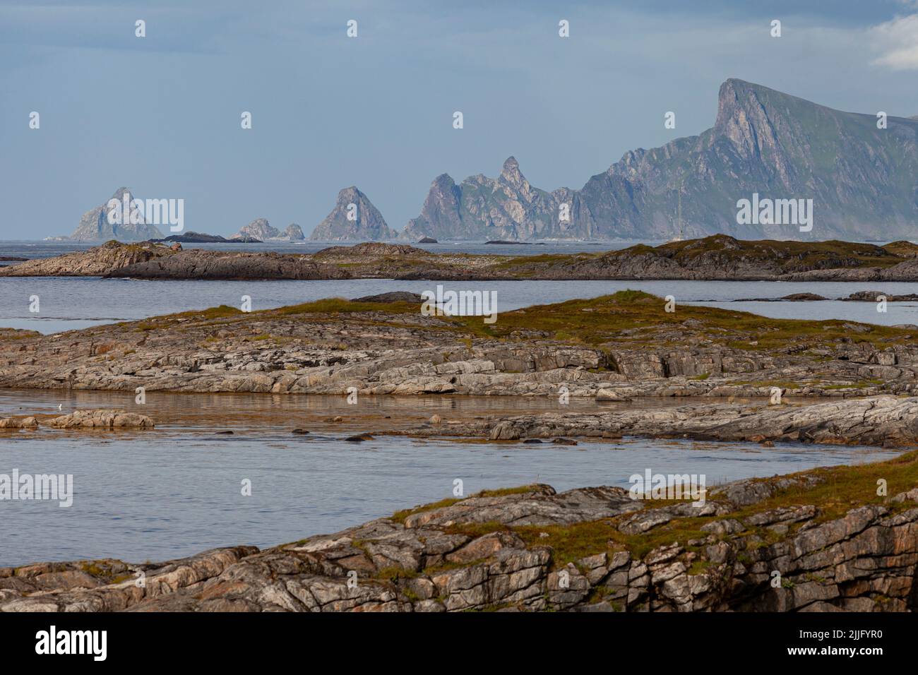 Shoreline of Norway with tall rocky cliffs of Måtind and a calm sea. Stock Photo