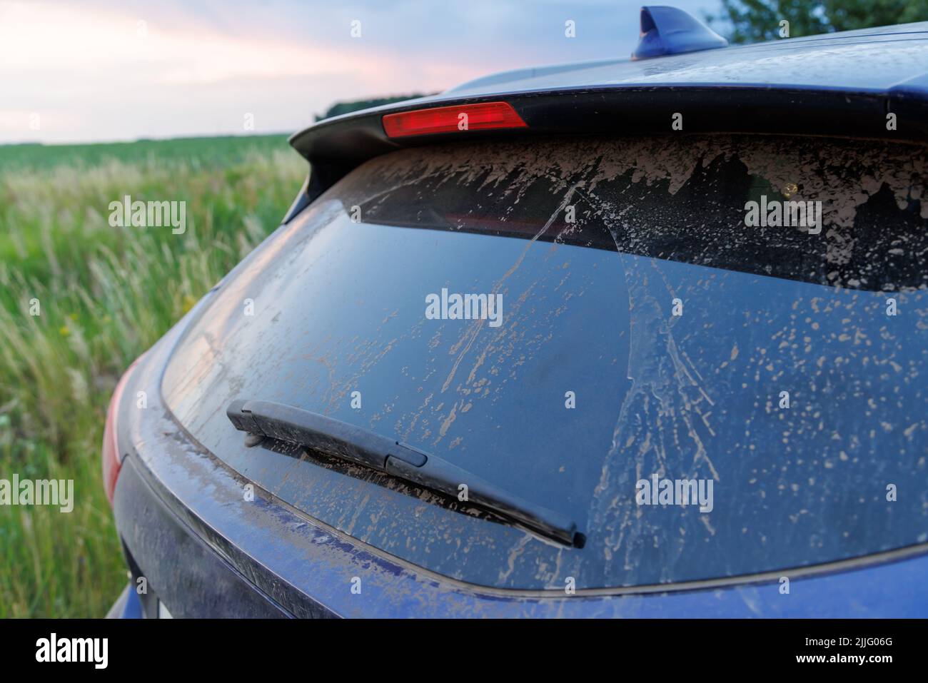 Dirty car glass with wiper and third brake light, rear window covered