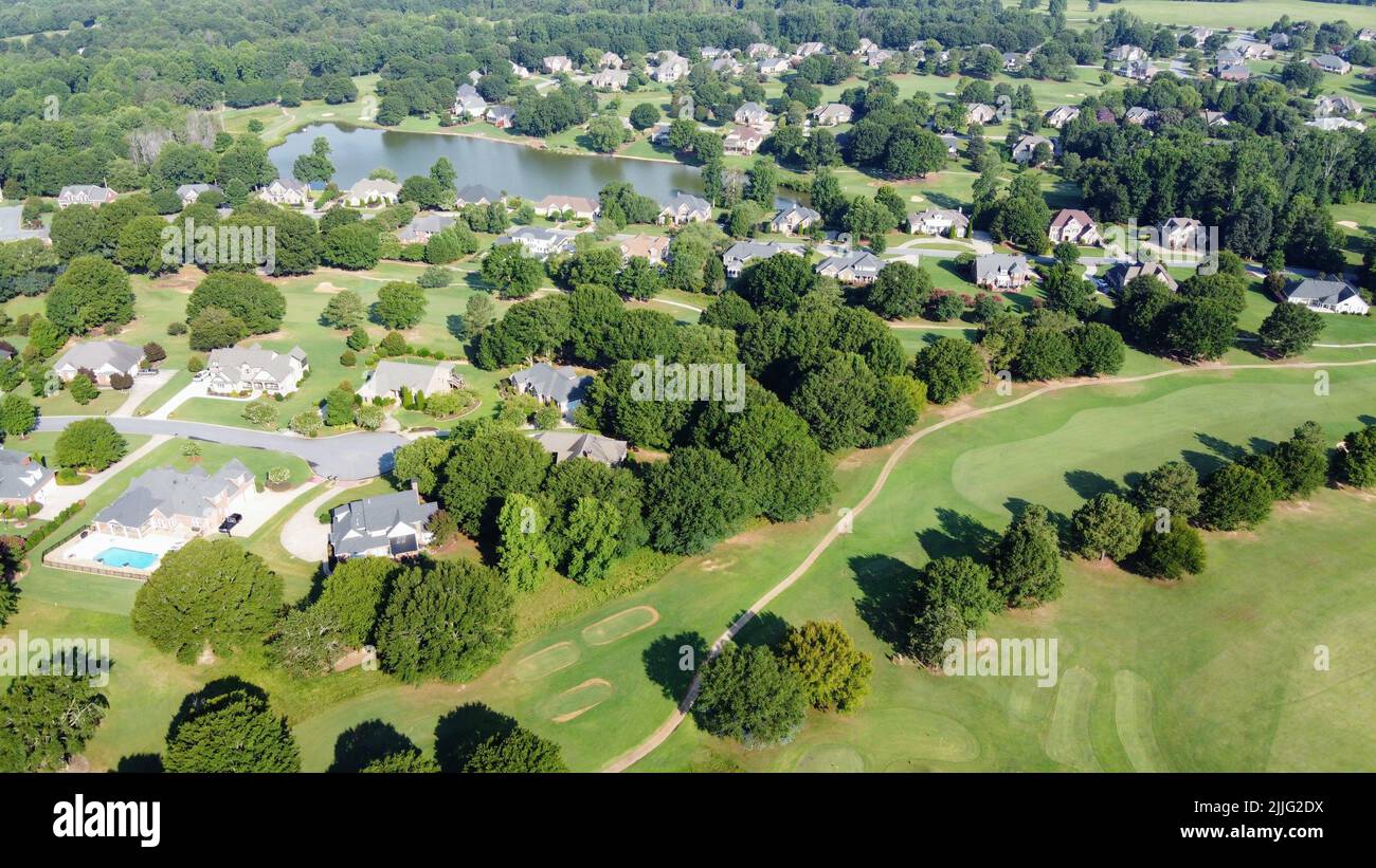 An aerial view of houses surrounded by trees and fields in countryside ...
