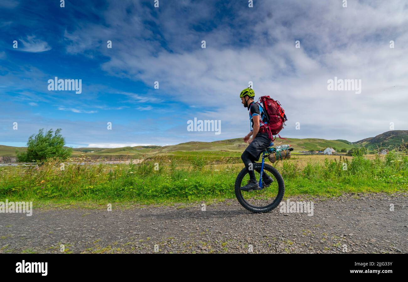 Bettyhill, Scotland, UK. 26 July 2022. Luke Evison riding his unicycle at Bettyhill in the Scottish highlands during his Scotland on One Wheel charity cycle odyssey. Luke ,39, from Bristol is riding solo and unsupported for approximately 225 miles across the Scottish Highlands to raise money for the charities Parkinson’s UK and Mind UK. Luke’s brother was diagnosed with Parkinson’s 6 years ago. Luke finishes his trip at Thurso. Donations can be made at the following website. Collectionpot.com/pot/onewheel.   Iain Masterton/Alamy Live News Stock Photo