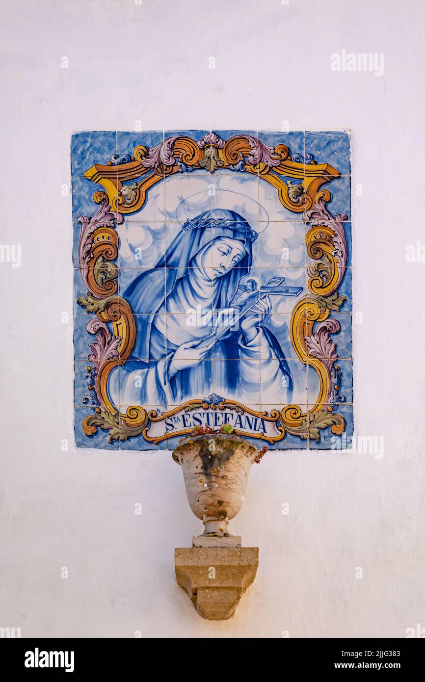 Mural of the holy Sta Estefania made of 42 painted ceramic tiles called azulejos on a house wall, Obidos, Portugal Stock Photo