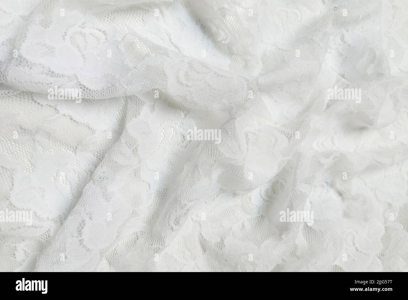 White guipure with roses. Crumpled or wavy fabric texture background. Abstract linen cloth soft waves. Natural yarn. Smooth elegant luxury cloth Stock Photo