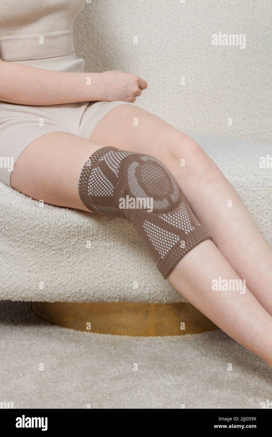 Knee support brace on a woman leg. girl in an orthosis in the