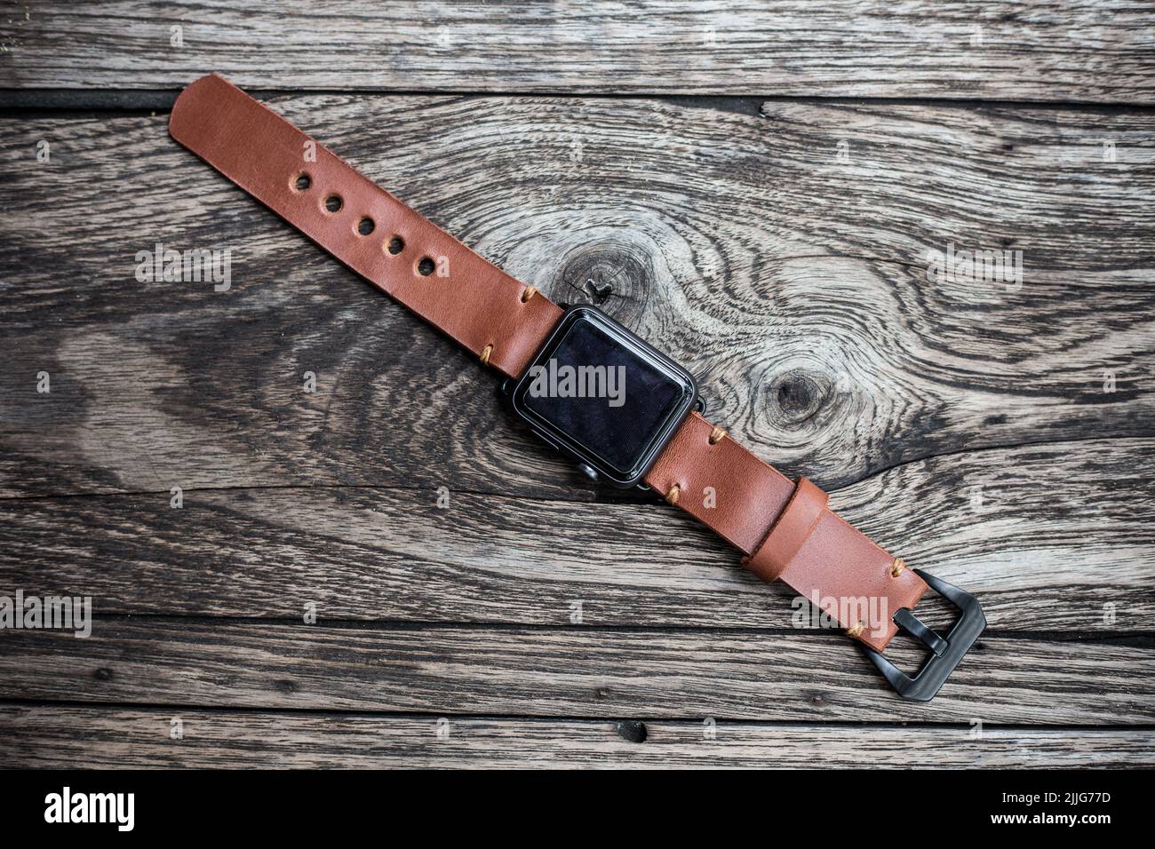 Genuine brown leather watch strap on wood background, Craftsmanship