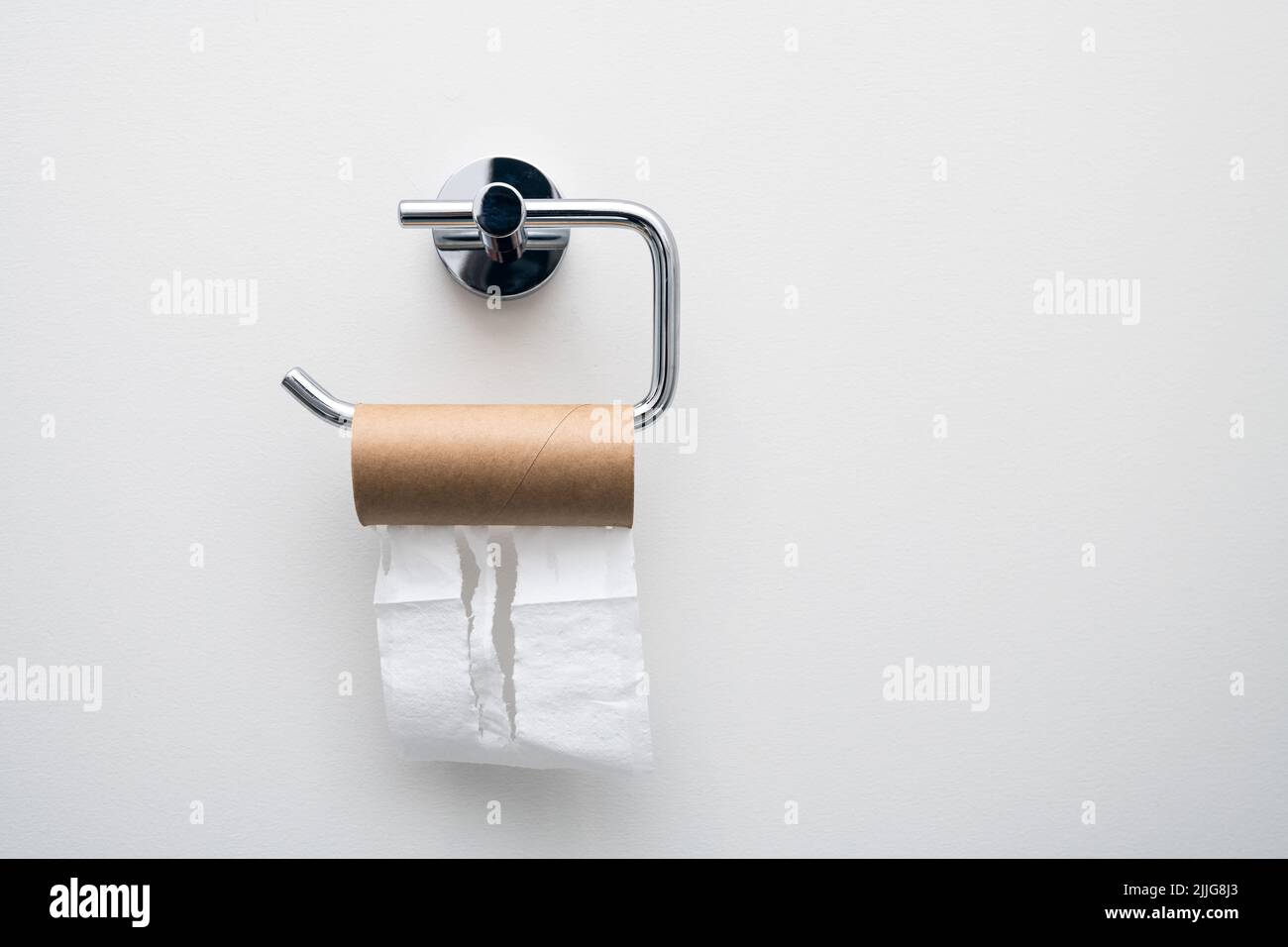 Toilet paper empty roll hanging on the wall. Epic fail concept Stock Photo