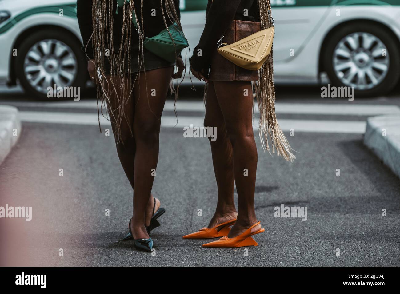 MILAN, ITALY - FEBRUARY 24: Street style outfit - girls wearing Prada purses and shoes. Stock Photo