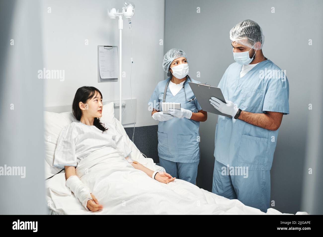 Two modern medical specialists working in emergency room with young