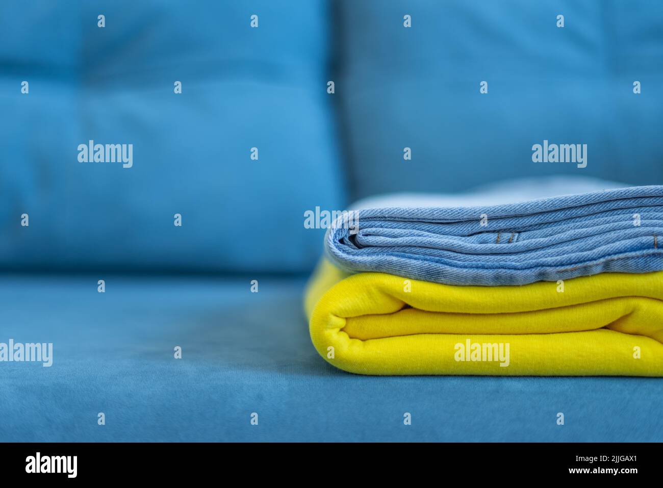 clothes of bright colors are neatly stacked. yellow blue colors of the Ukrainian flag. Stock Photo