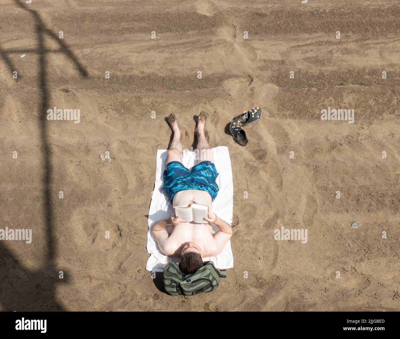Las Palmas, Gran Canaria, Canary Islands, Spain. 26th July, 2022. Tourists, many from the UK, swelter on the city beach in Las Palmas during a heatwave on Gran Canaria. The south west of the island registered 45 degrees Celicius on Monday. Credit: Alan Dawson/ Alamy Live News.  Stock Photo