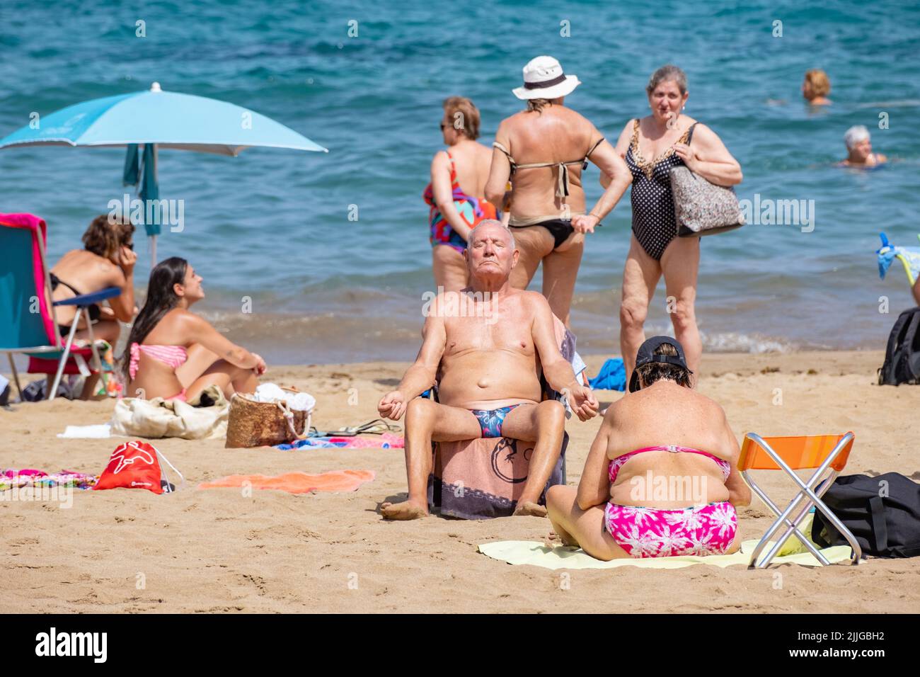 Las Palmas, Gran Canaria, Canary Islands, Spain. 26th July, 2022. Tourists, many from the UK, swelter on the city beach in Las Palmas during a heatwave on Gran Canaria. The south west of the island registered 45 degrees Celicius on Monday. Credit: Alan Dawson/ Alamy Live News. Stock Photo