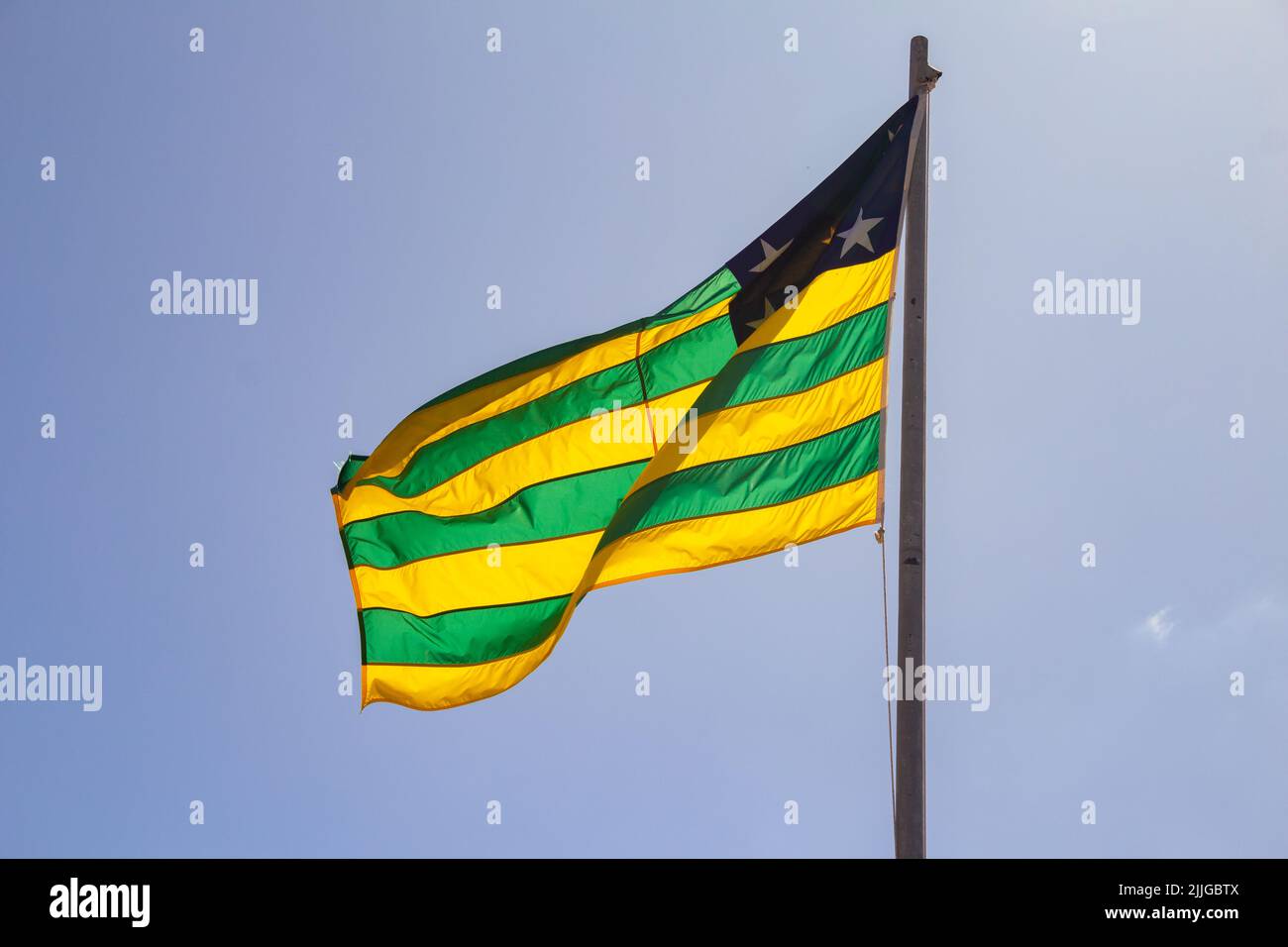 Brasília, Federal District, Brazil – July 23, 2022:  Goias state flag flying and fluttering in the wind with blue sky in the background. Stock Photo