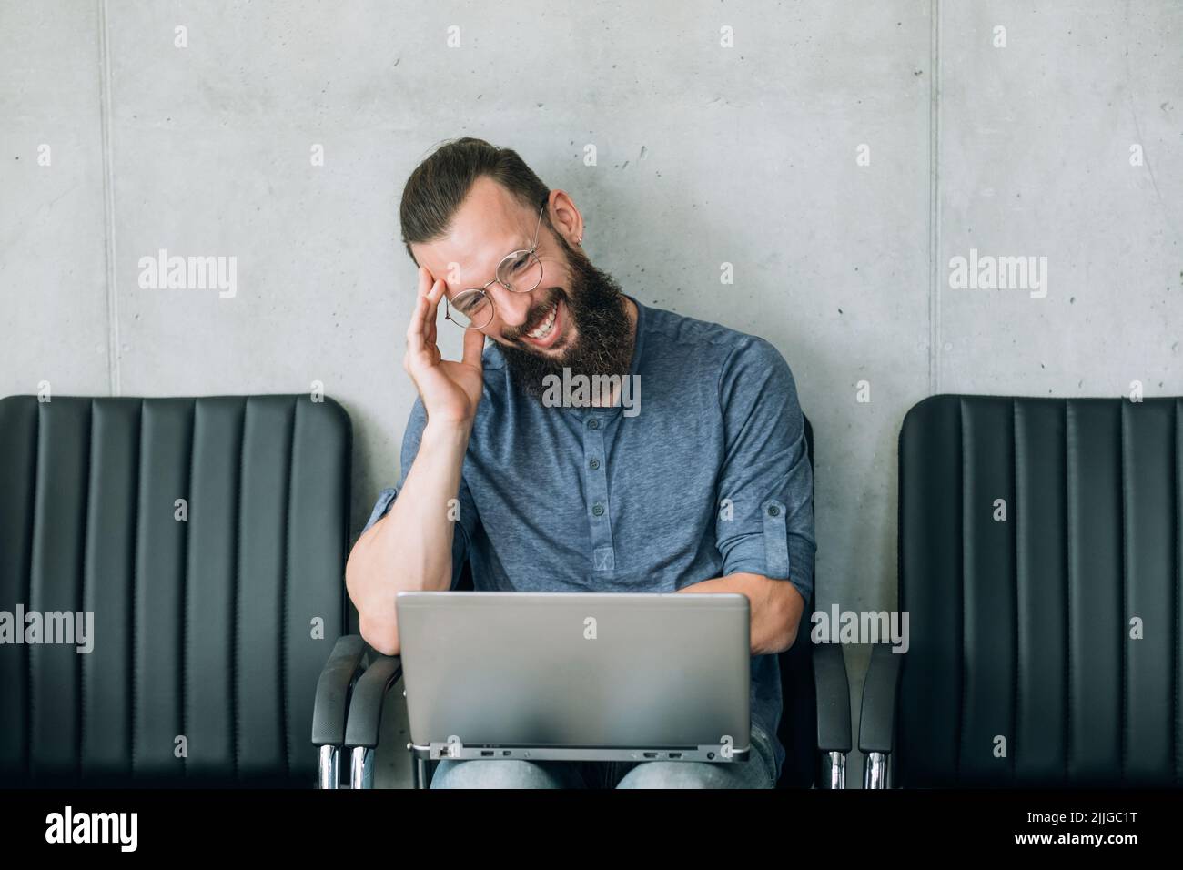 funny videos idle leisure man laughs watch laptop Stock Photo
