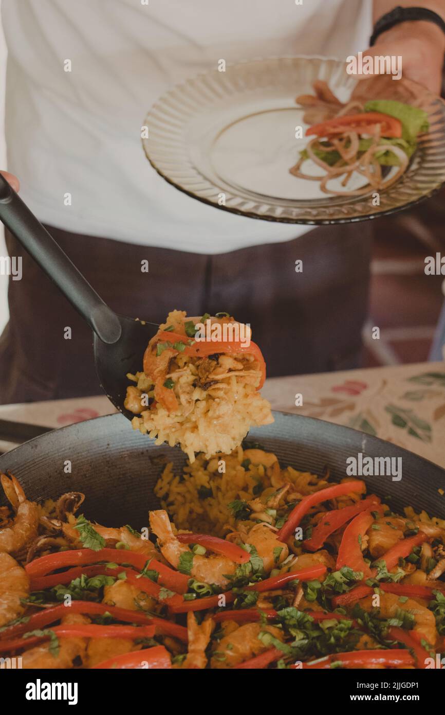 serving a spoon of seafood paella Stock Photo Alamy